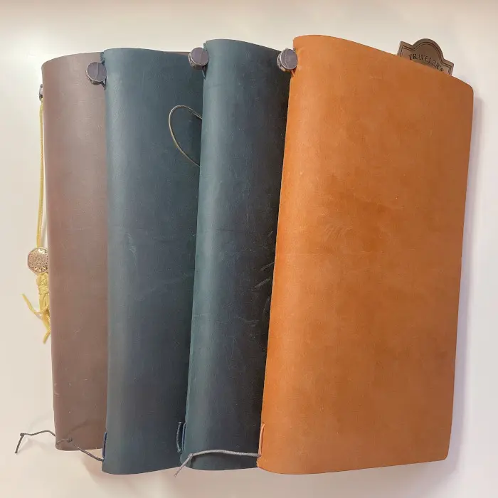 Four regular size Traveler’s Notebooks in brown, navy, and camel leather covers