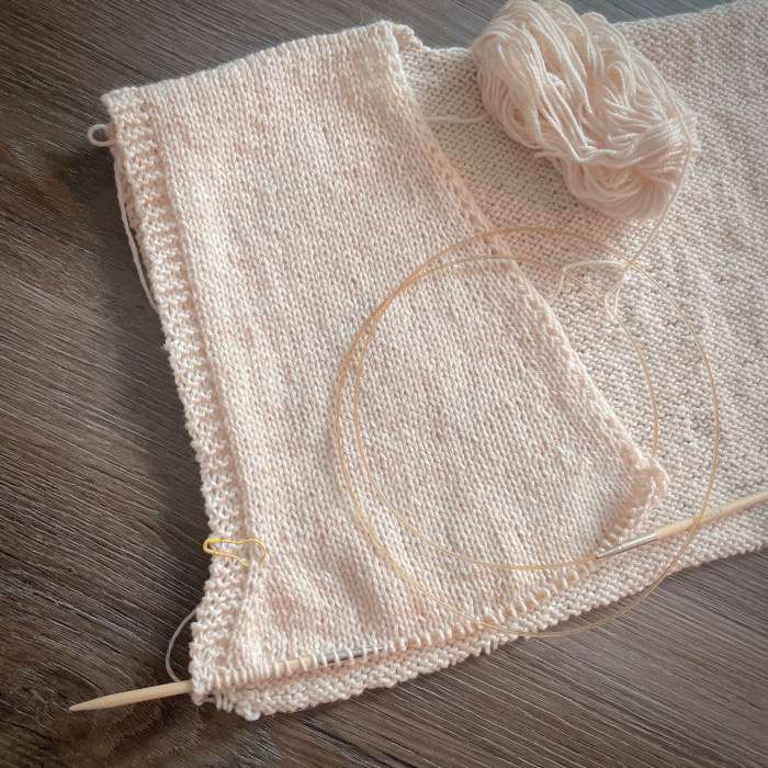 Ivory Top Sol knitting project in progress, flat piece on circular needles with yarn ball placed on top