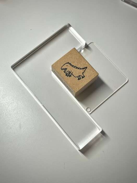 Wooden stamp with a bird design placed on a clear acrylic block.