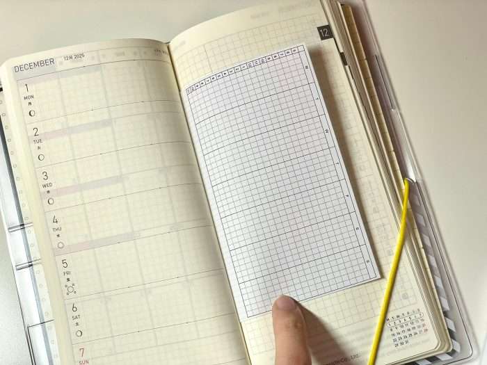 Hobonichi Weeks December weekly spread with a time tracker sheet placed for setup