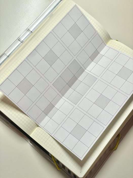 Printed mandal-art goal sheet laid open on top of a Hobonichi Weeks notebook