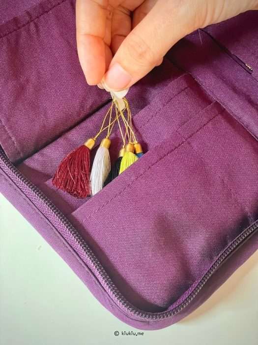 Tassel stitch markers stored inside Lantern Moon needle case
