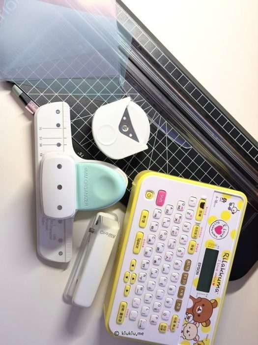 Supplies for making yarn sample cards including label maker hole punch paper cutter and clear file