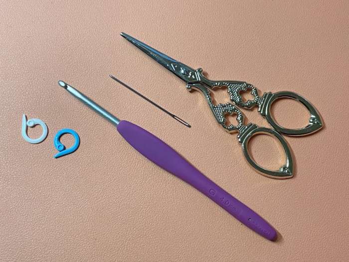 Clover hook, marker rings, yarn needle, scissor