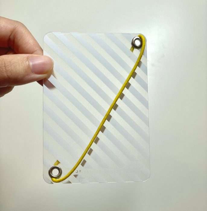 Hobonichi Weeks clear page keeper with yellow elastic band held in hand