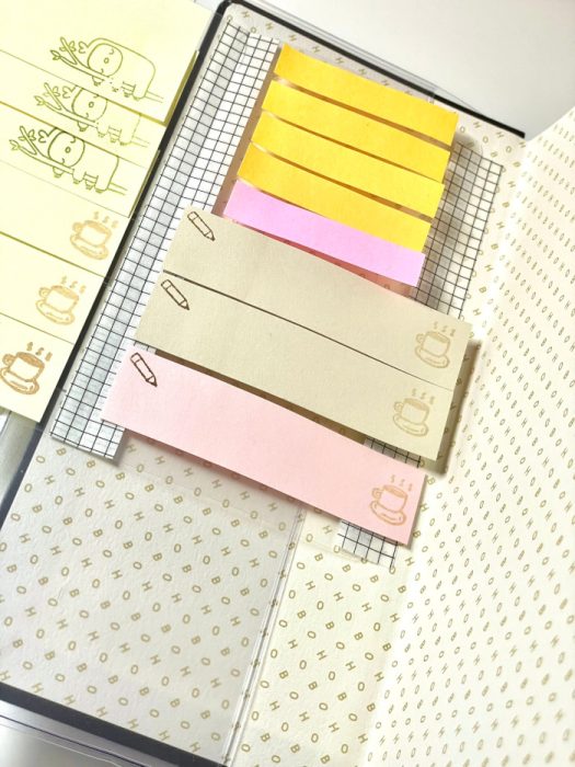Inside of fold-out organizer holding assorted colored sticky notes and stamped memo tabs
