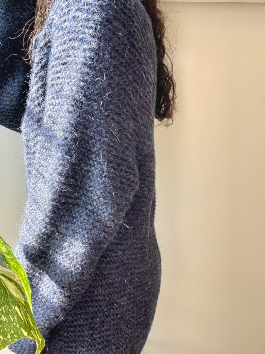 side view of a navy textured Kiki cardigan showing fuzzy yarn detail in natural light