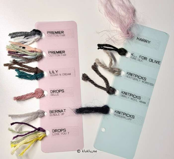 Completed yarn sample cards laid out with labeled yarn scraps organized by brand and color