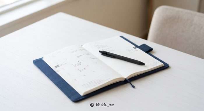 A photo of a Hobonichi Techo planner and a pen placed on a white desk