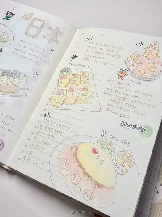 A close-up of an open Japan travel journal with watercolor food sketches, handwritten Korean notes, small stickers, and illustrated memories from the trip.